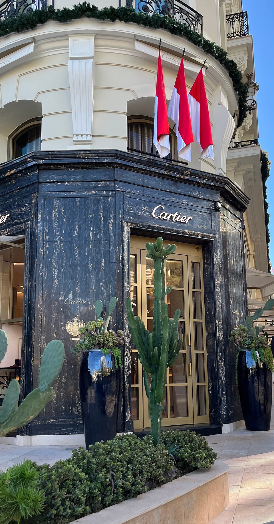 The Cartier boutique on the Avenue des Beaux-Arts in Monaco, a stone corner building with dark shopfronts and the Cartier name above the windows.
