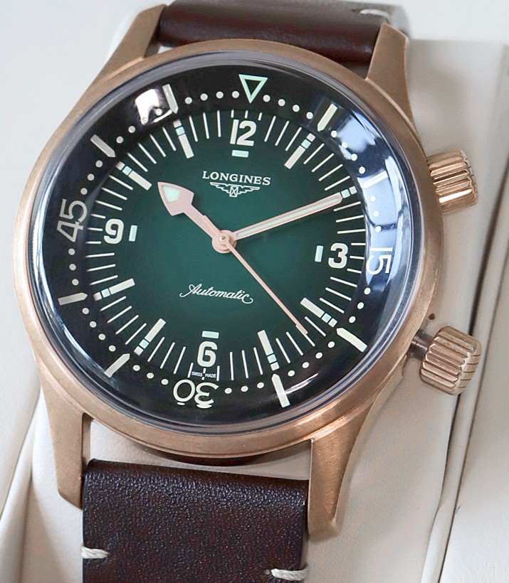 A Longines Legend Diver in a bronze case with a dark green dial, twin screw-down crowns and a brown leather strap. The internal rotating bezel is marked in minutes, the hands and indices in aged cream lume.